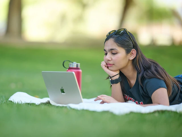 Female student using laptop on grass