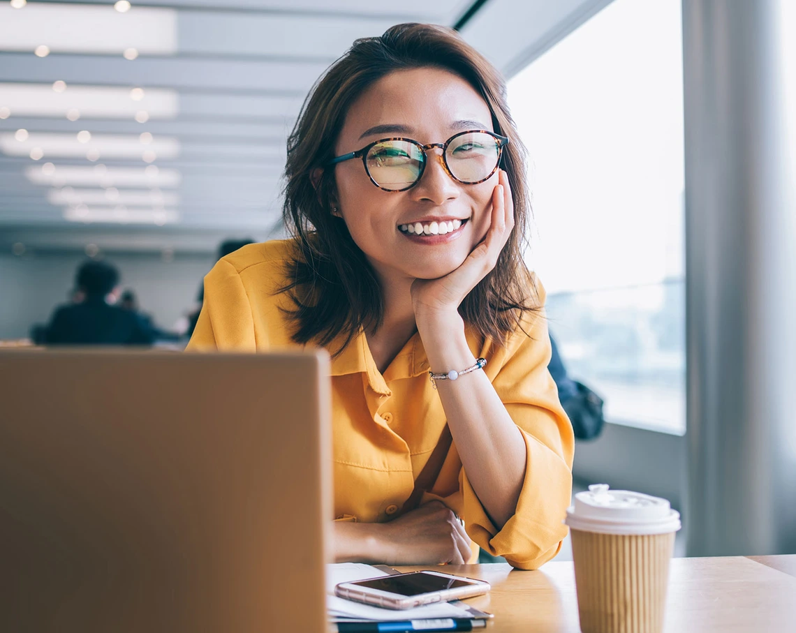 Female Asian student with coffee and laptop