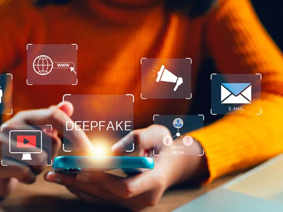 Person holding smartphone with "deepfake" text