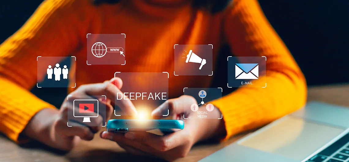 Person holding smartphone with "deepfake" text