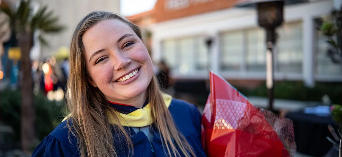 Smiling graduate with flowers