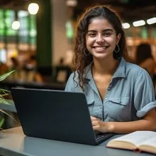 Student with laptop and book in coffee shop